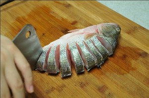 將鱸魚清洗干凈，從脊椎處切斷至腹部，腹部保留1cm左右不要切斷。