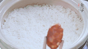 煮開后轉(zhuǎn)小火，當(dāng)米飯出現(xiàn)小孔時(shí)，鋪上金字麻辣香腸。