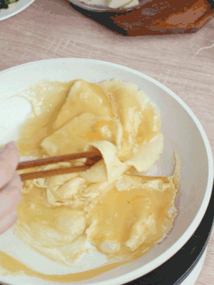 油6成熱時，下雞蛋液，邊緣凝固時翻拌成塊狀。