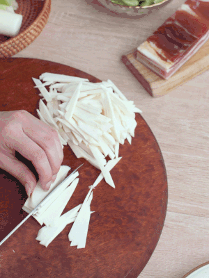 茭白切細(xì)絲，鹽水中浸泡防止氧化。