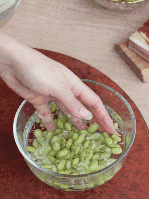 青豆剝殼，搓去外衣。