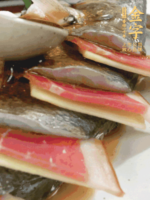 魚肚中塞蔥結(jié)、火腿片，魚身上碼放姜片、火腿片，倒入混合的料汁。