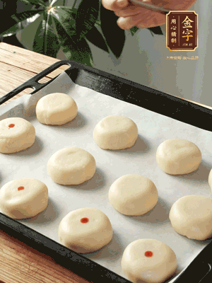 收口向下放在案板上，輕輕將月餅坯按扁，用筷子點(diǎn)紅點(diǎn)做裝飾